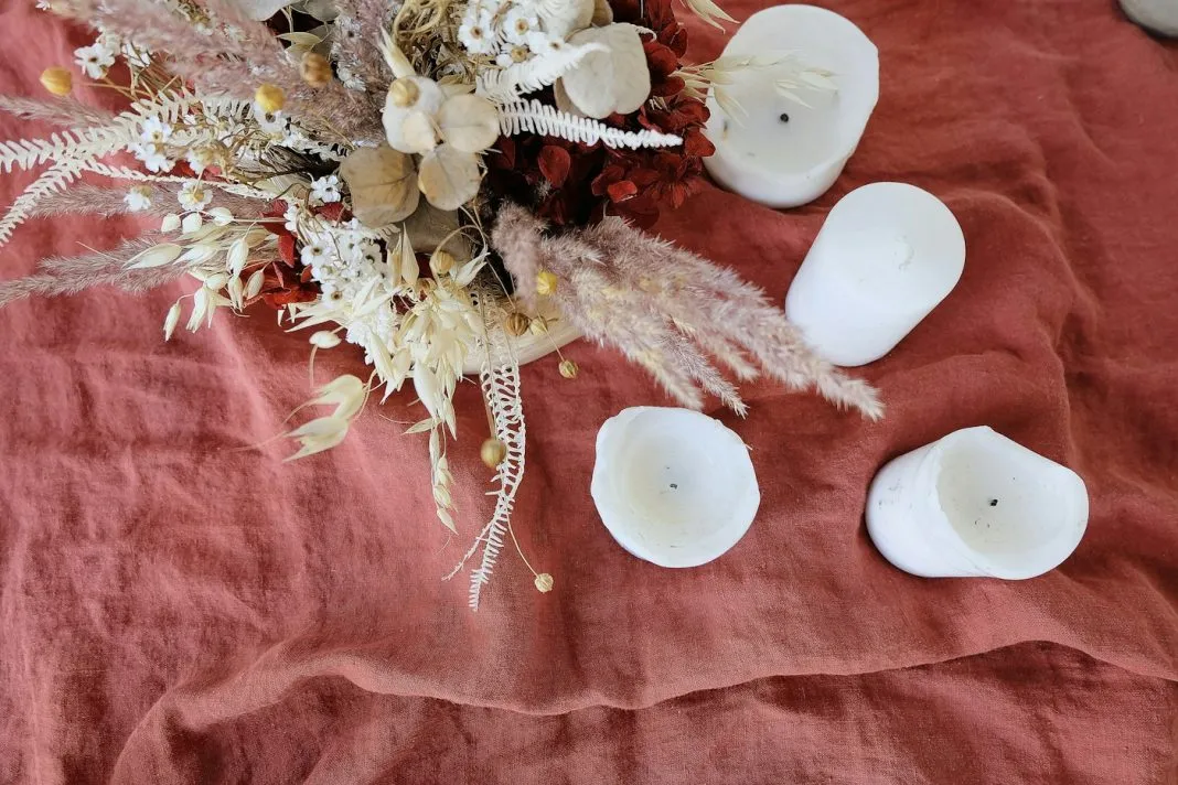 Bouquet de fleurs blanches posé près d’une bougie allumée