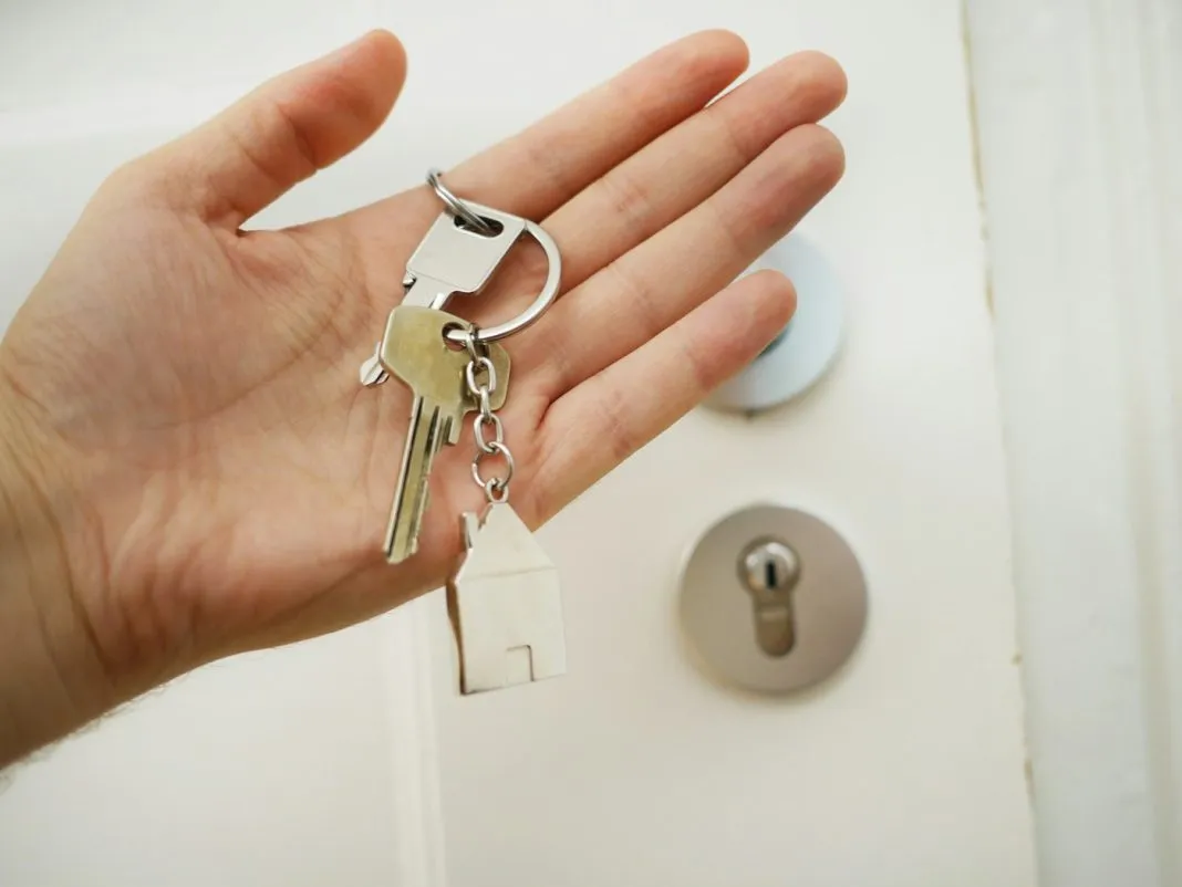 Personne âgée devant la porte de son appartement en location