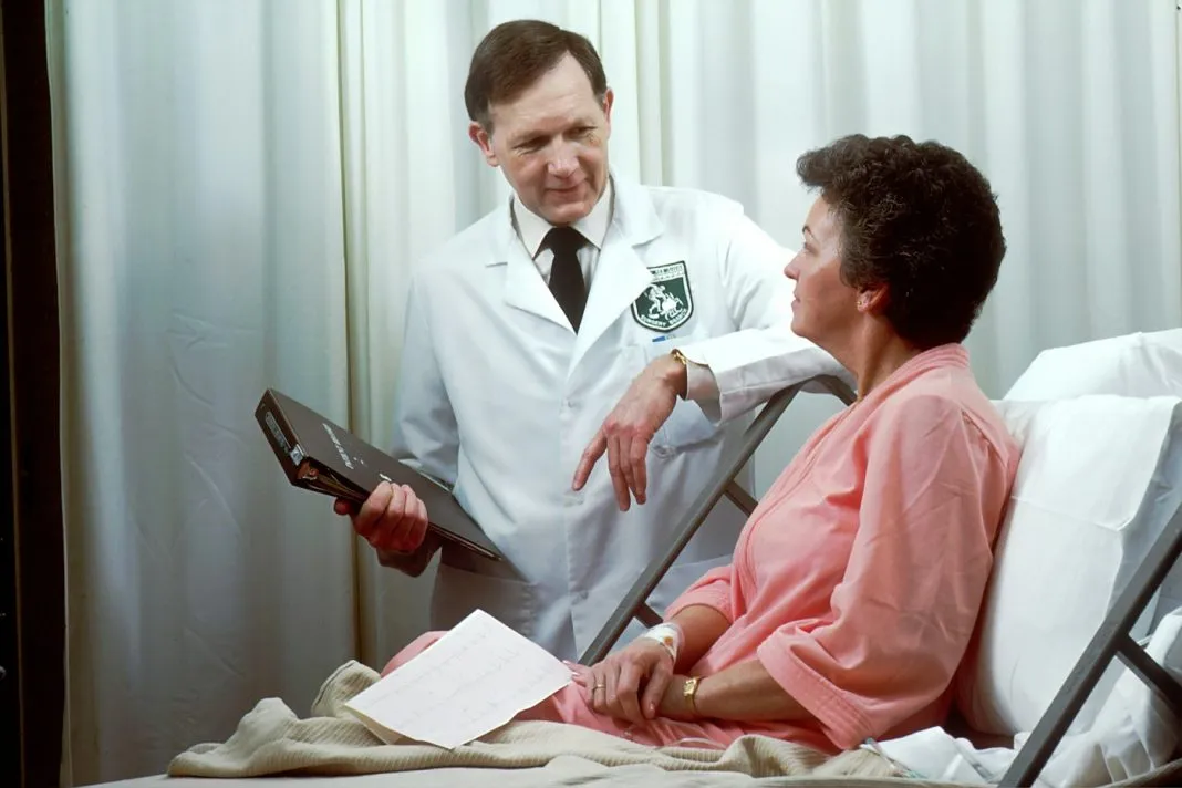 Médecin en consultation avec une patiente âgée accompagnée d’un proche